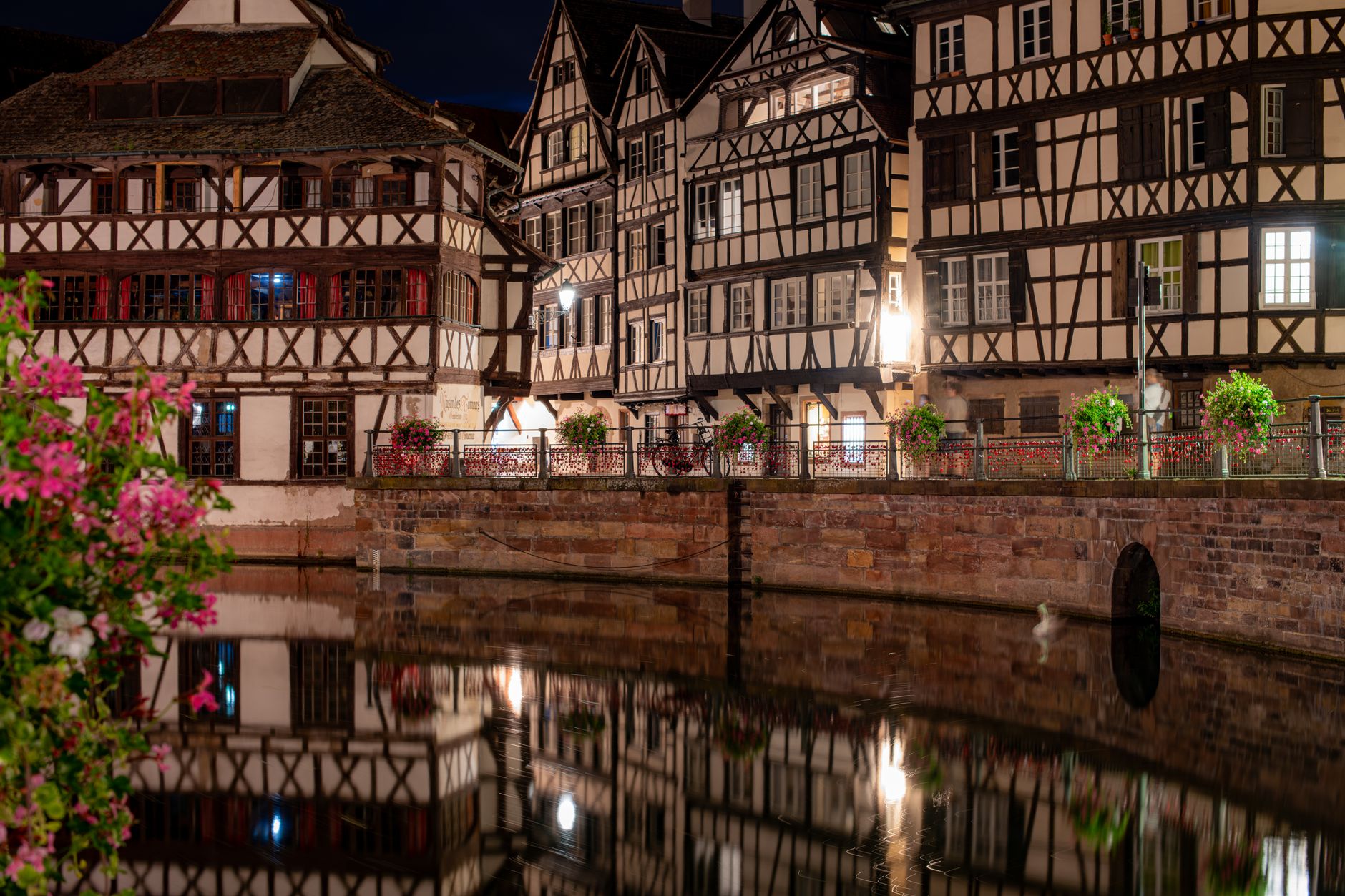 Les maisons à colombages de Strasbourg se reflétant dans l'eau à la nuit tombée