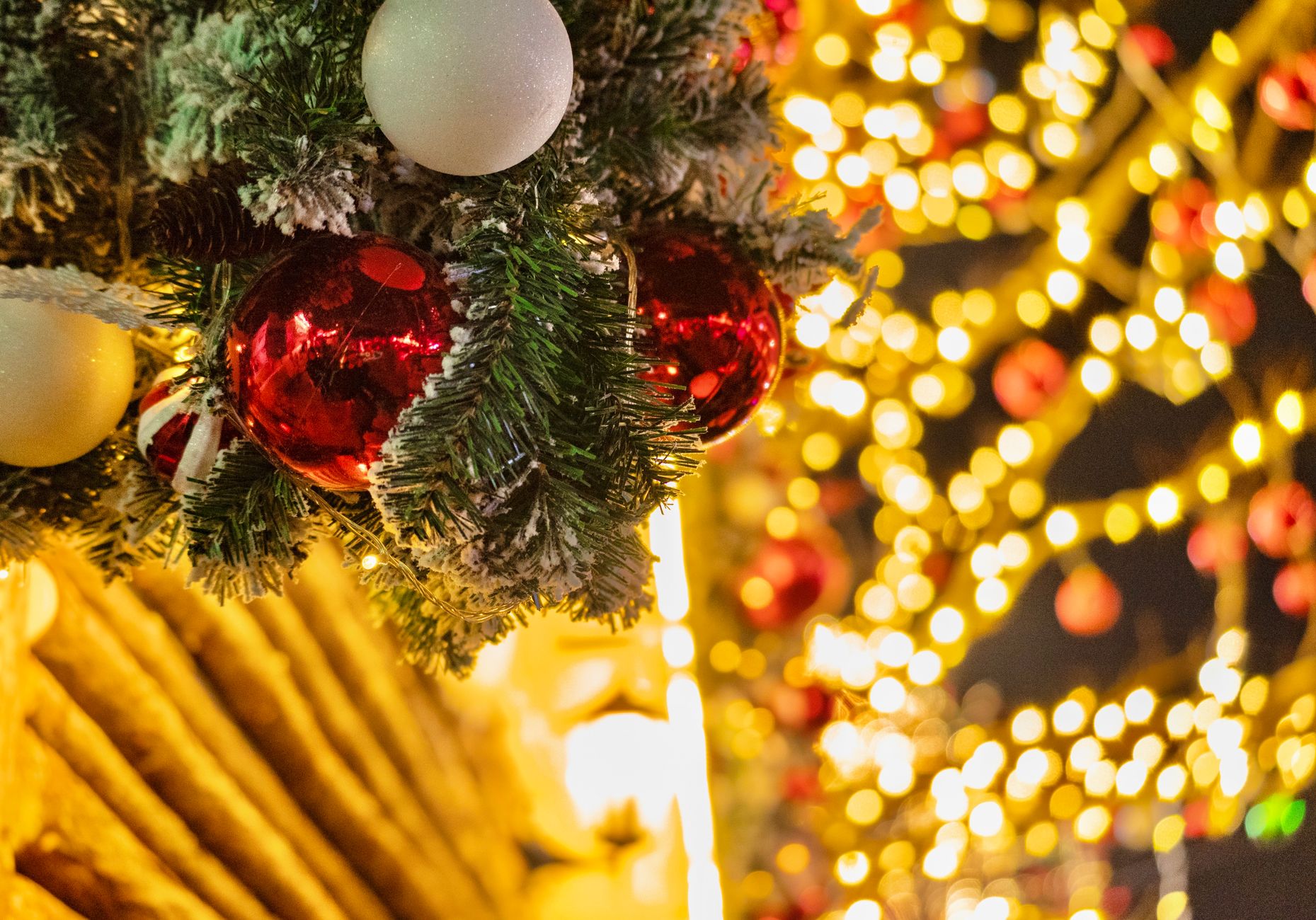 Boules et guirlandes d'un grand sapin de Noël illuminé